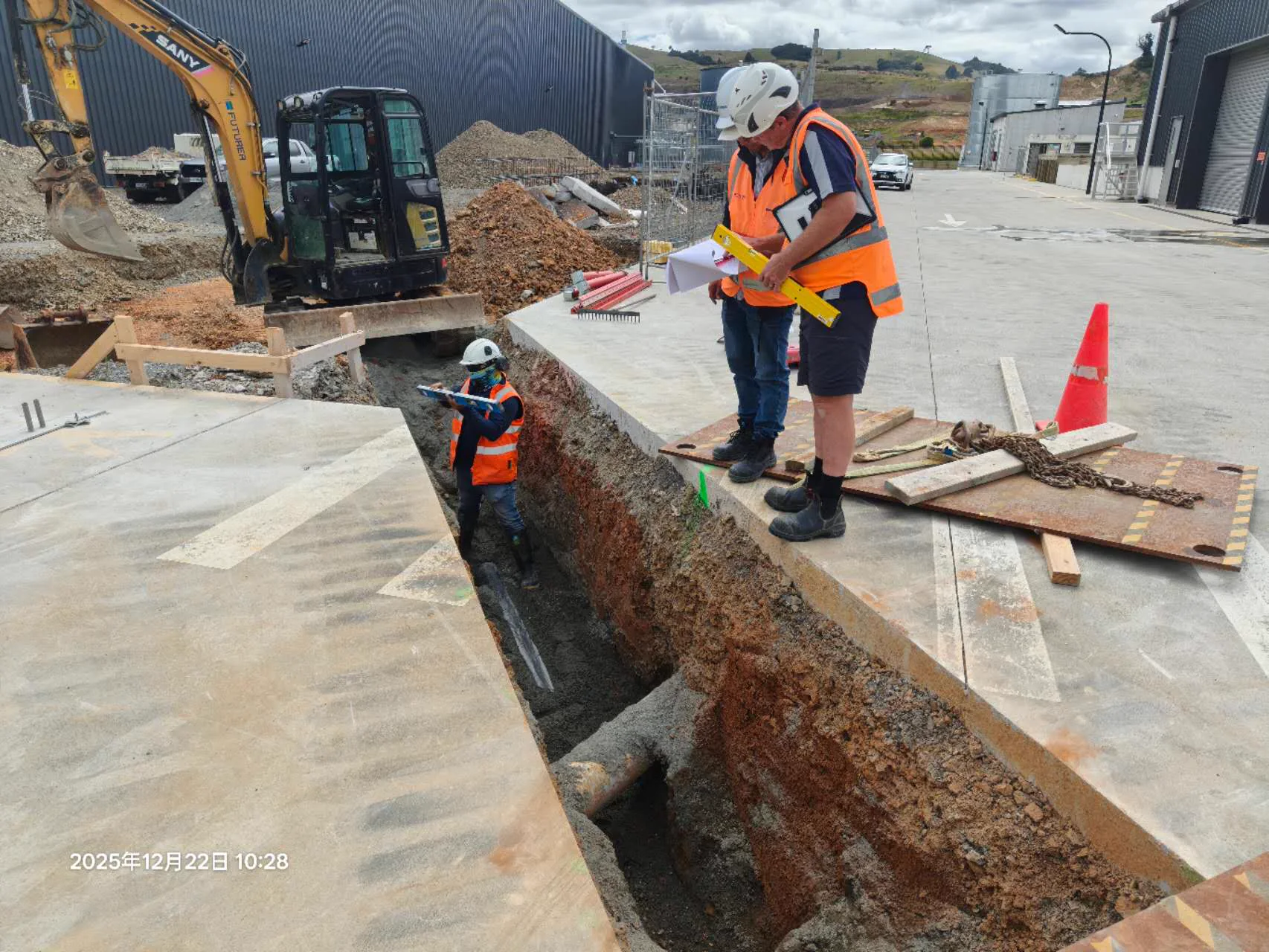 Site team checking an excavated service trench during construction