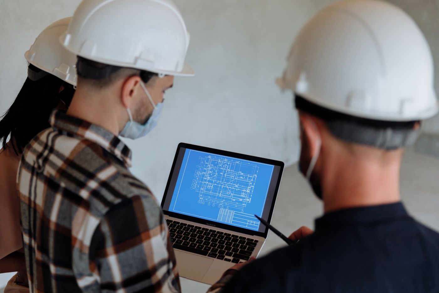 Illustrative photograph of construction professionals reviewing a digital building plan